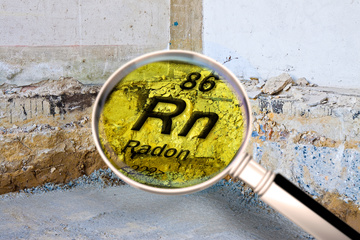 86 RN Radon symbol in magnifier looking at cracks in concrete