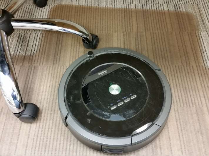 robotic vacuum cleaning carpet in an office